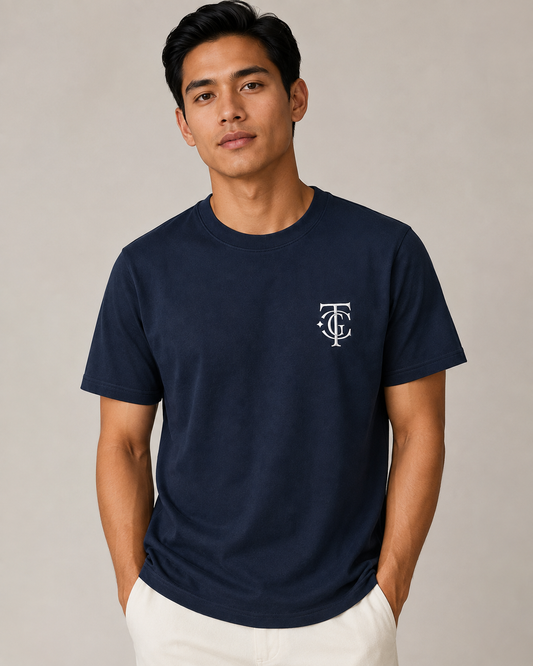A man wearing Navy TGC Essentials Embroidered Monogram Tee with white TGC chest logo.