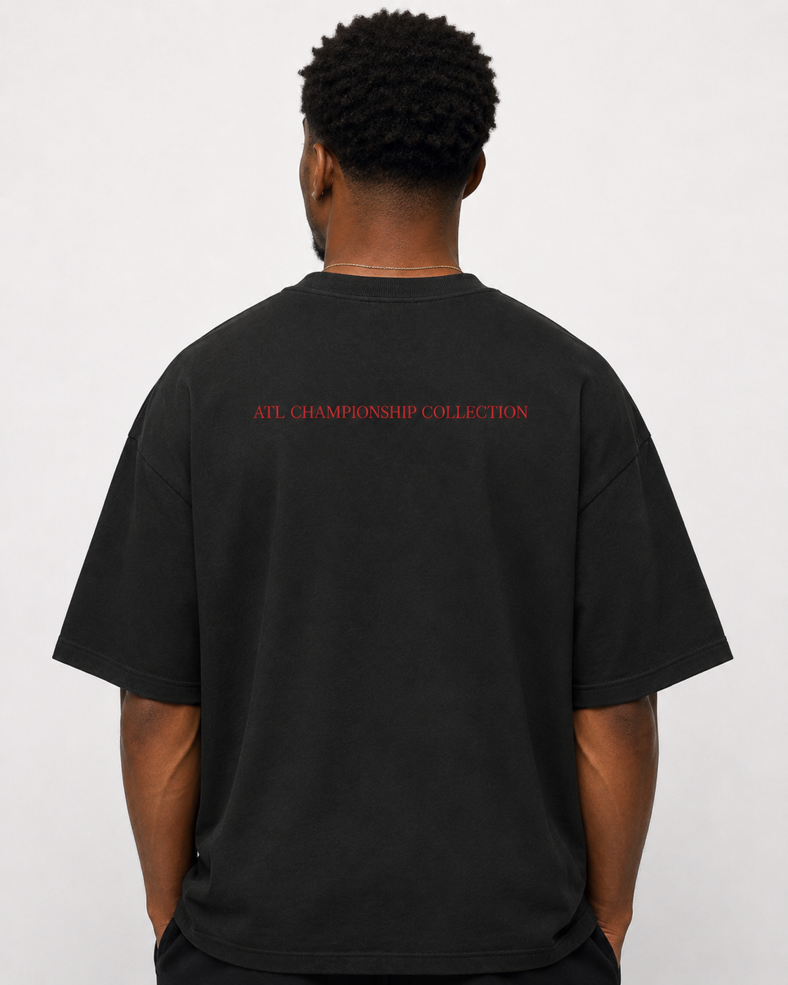 Black oversized ATL Hudson Championship DTG tee featuring two Hudson golfer characters, red ATL script artwork, and golf course background.