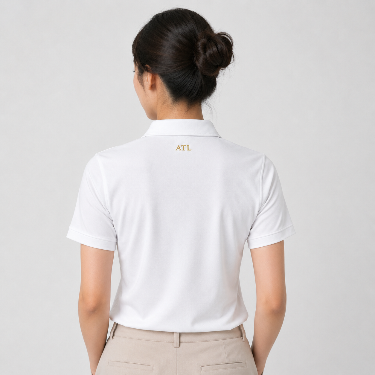 Female model wearing Championship White ATL Championship Performance Polo rear view.
