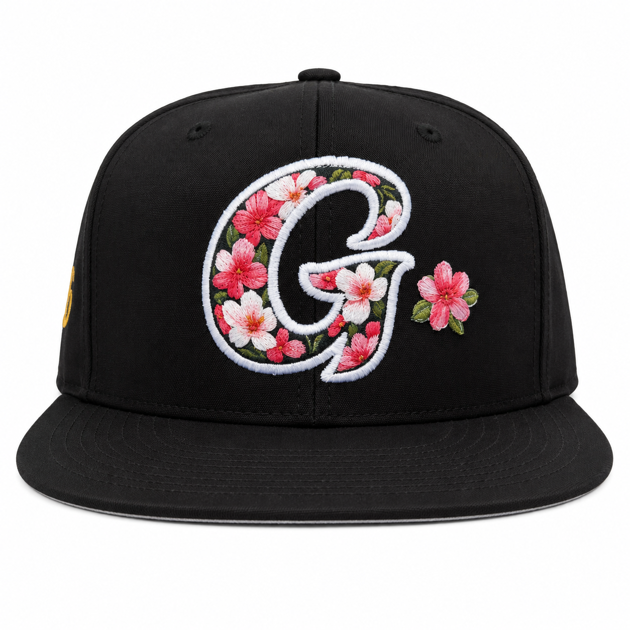 Black cap with floral letter 'G' design on a white background