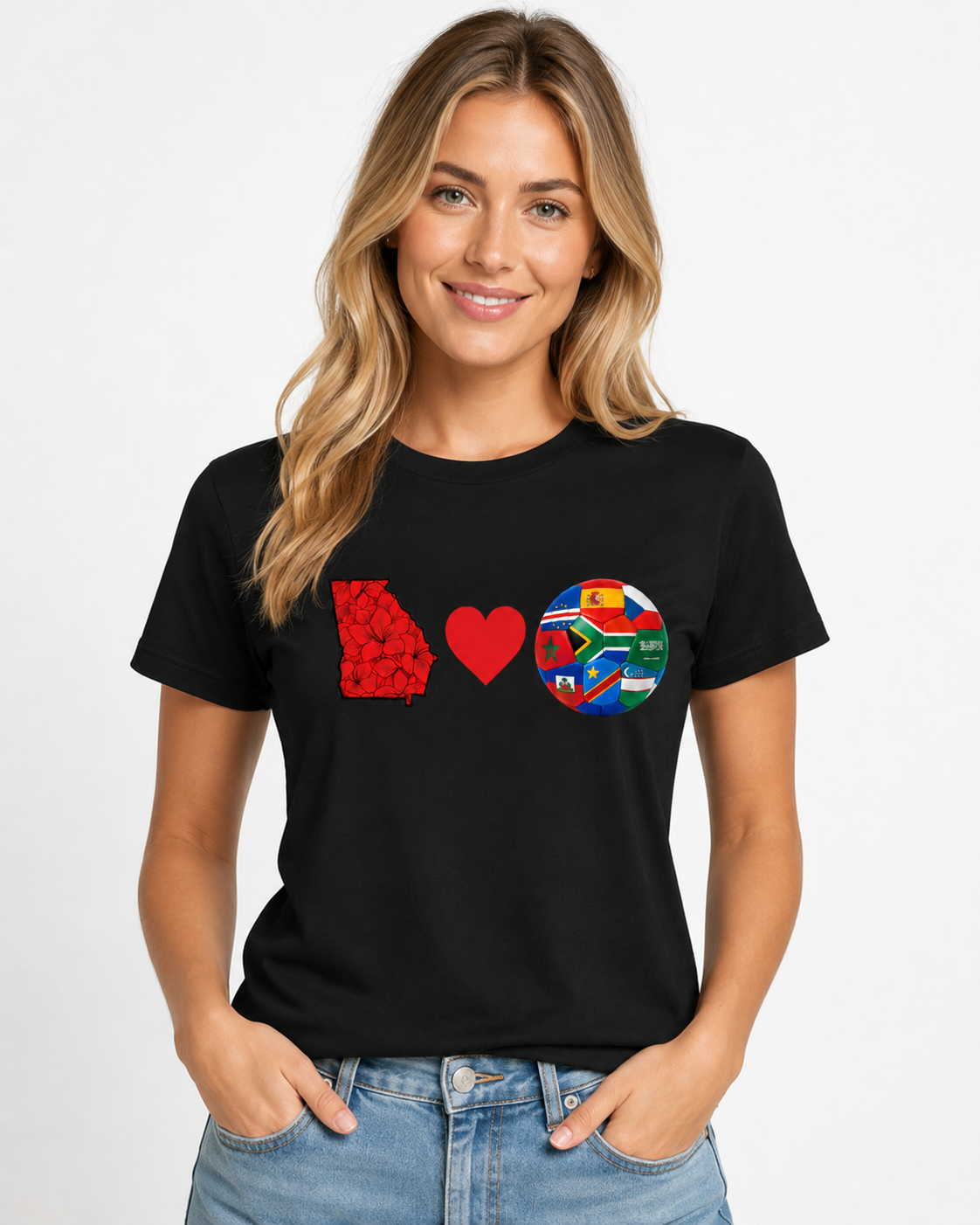 Female model wearing a black Georgia Loves Fútbol tee with Georgia state, heart, and multi-nation soccer ball chest graphic.