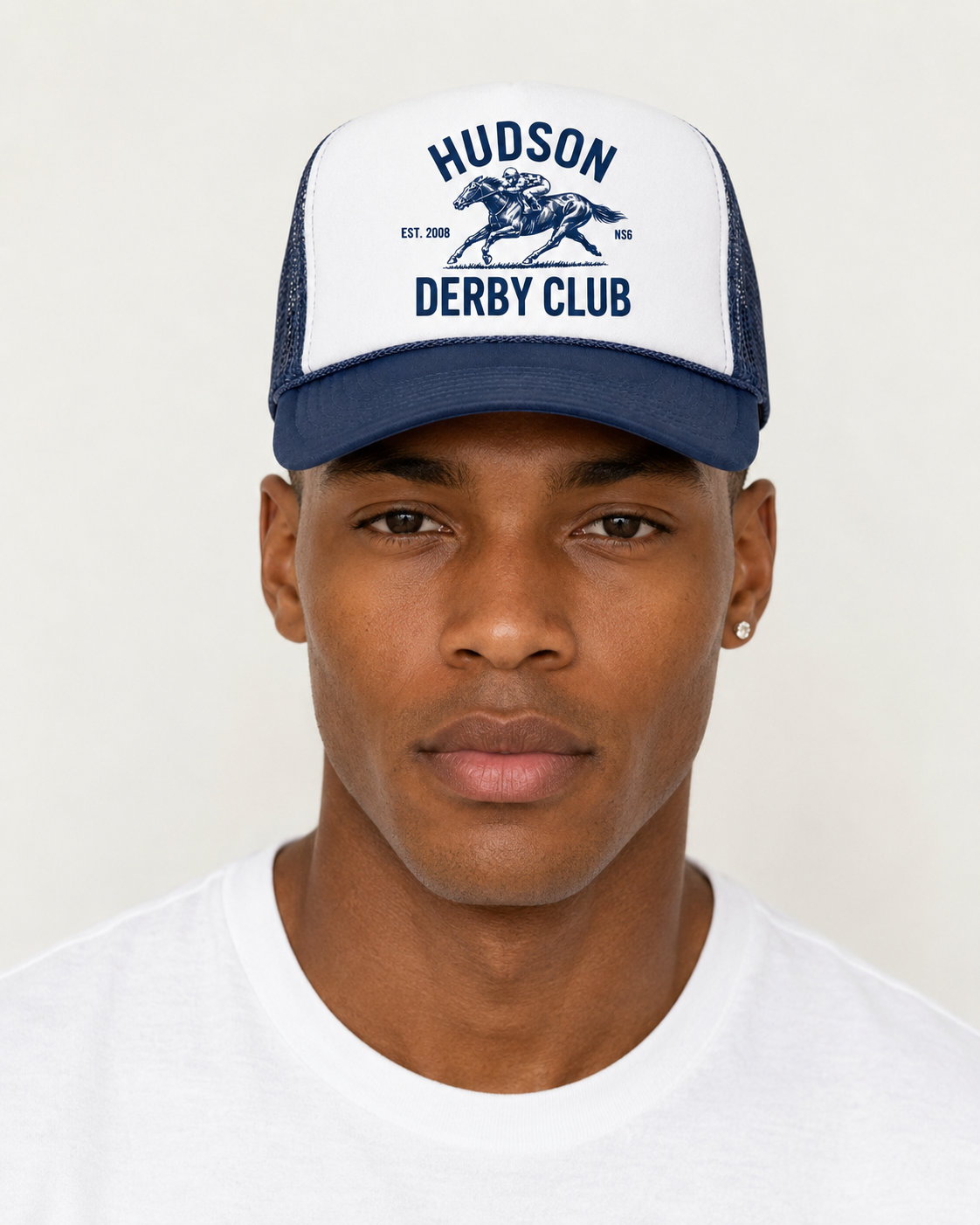 Man wearing a navy and white cap with 'Hudson Derby Club' text and logo on a plain background