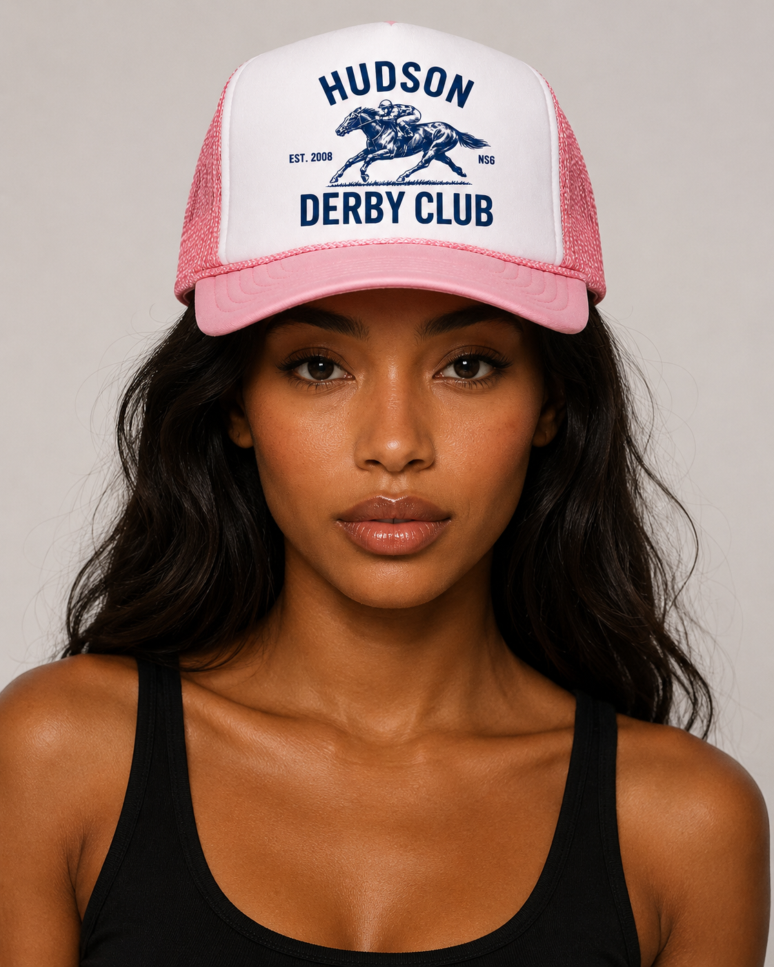 Woman wearing a pink and white cap with 'Hudson Derby Club' text and logo on a plain background