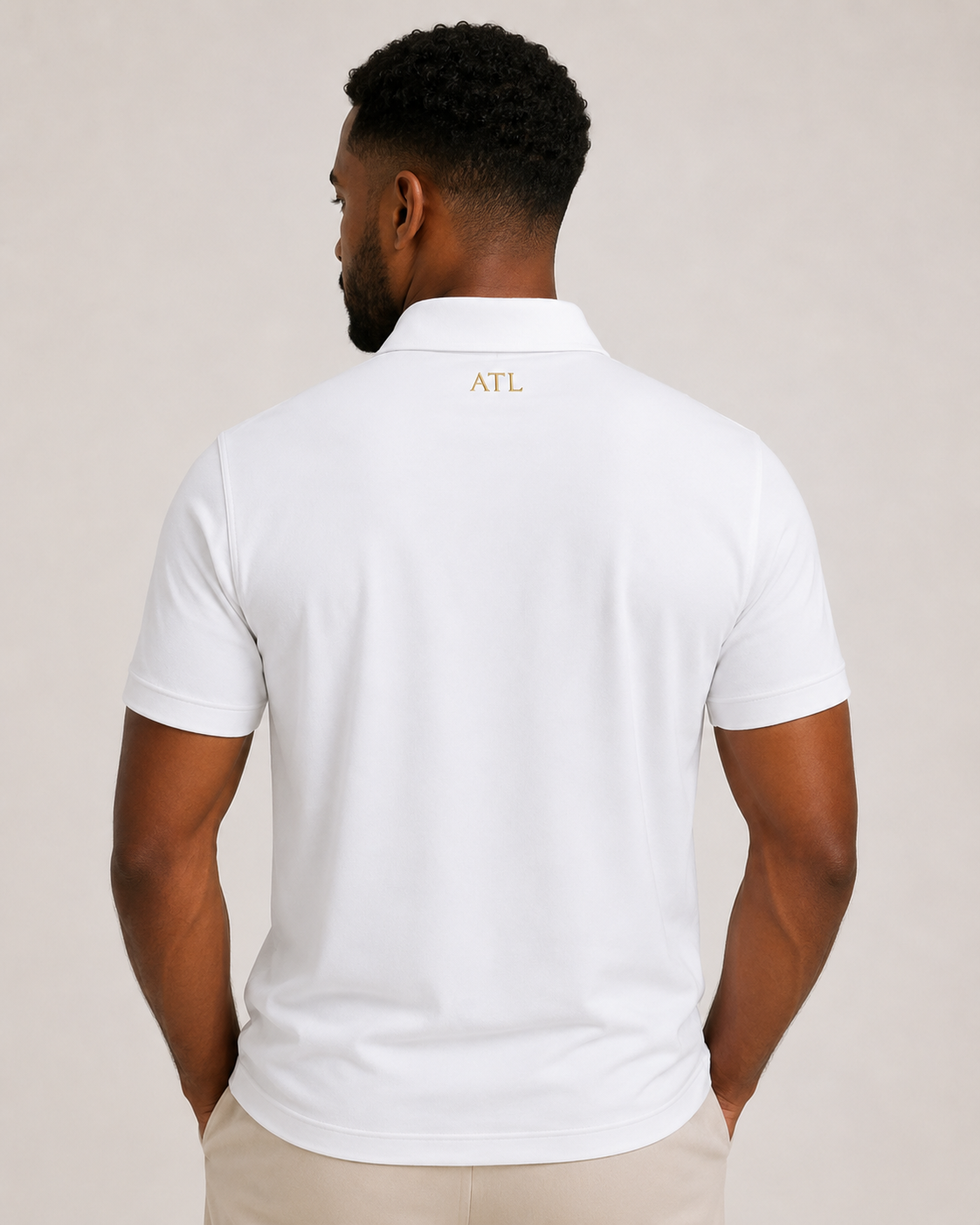 Male model wearing White ATL Championship Performance Polo rear view.