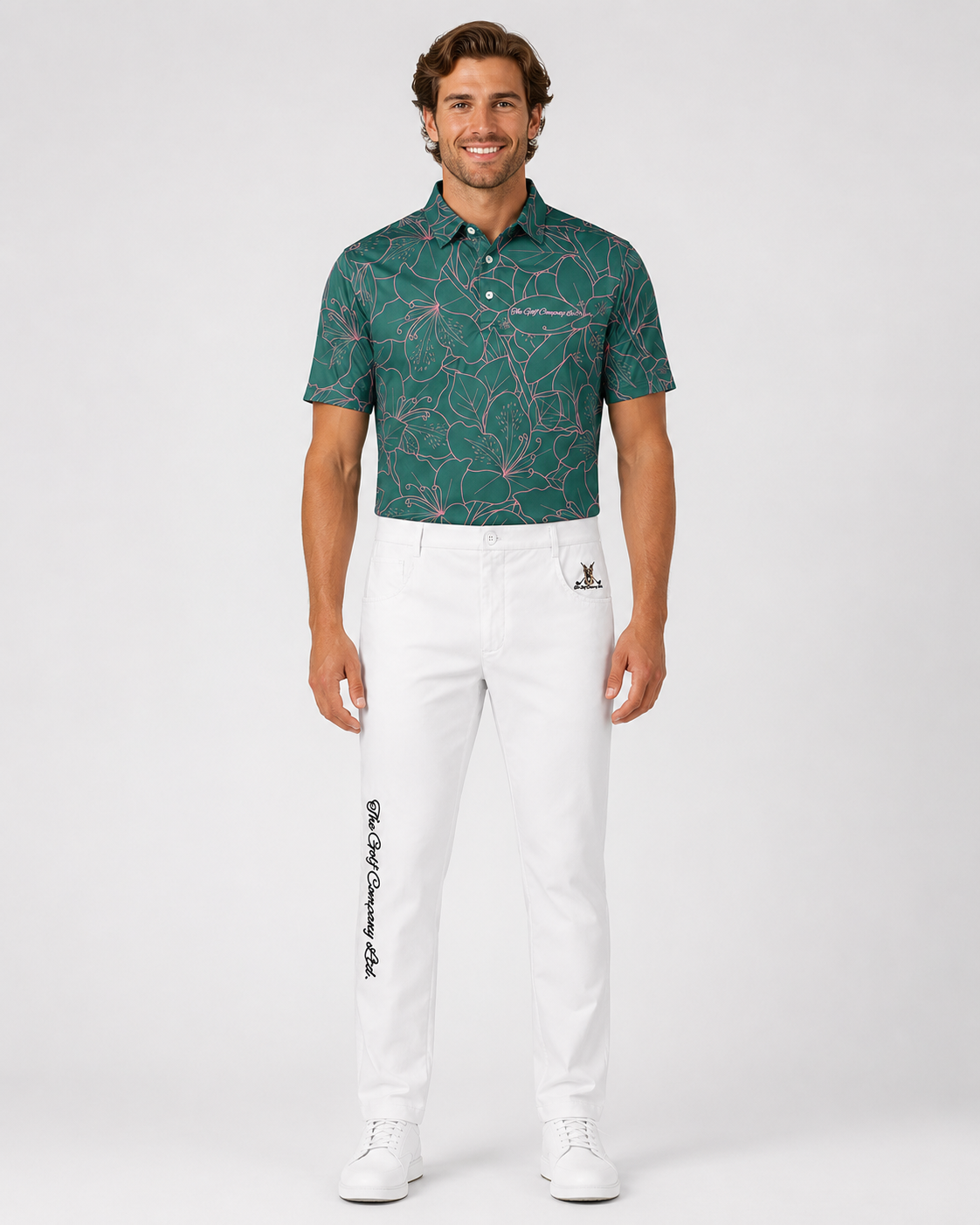 Man wearing a green patterned polo shirt and white pants on a white background