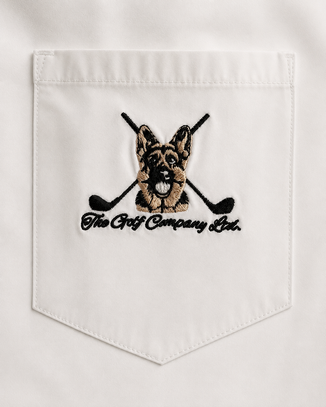 Embroidered design of a dog with golf clubs on a white fabric background
