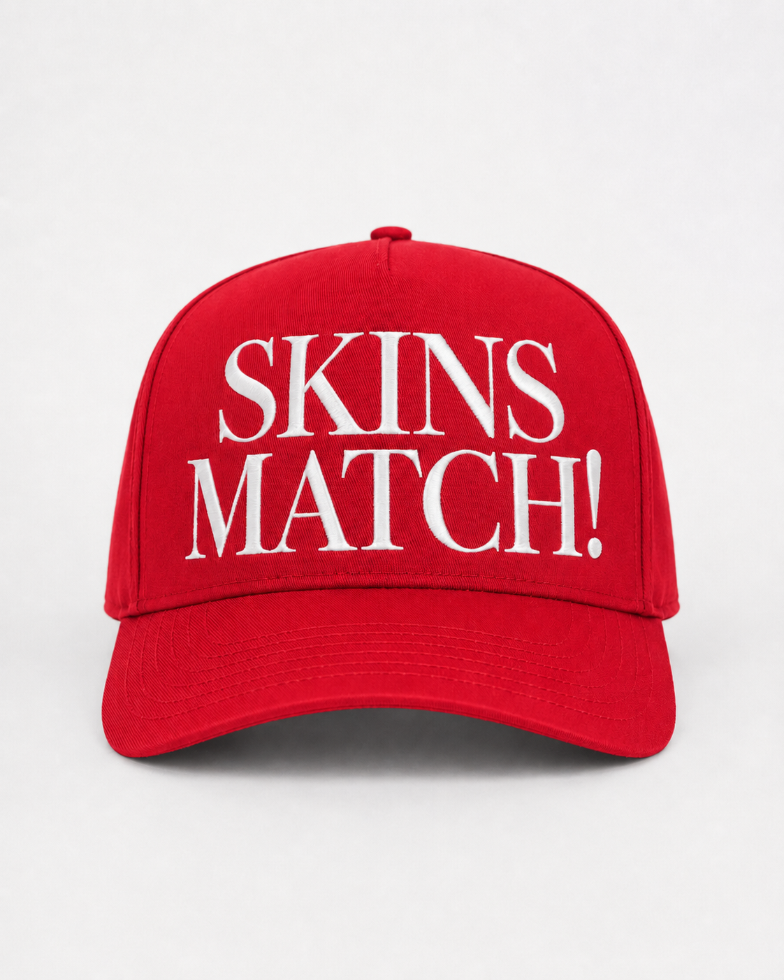 Championship red 5-panel snapback cap with white raised “SKINS MATCH!” embroidery on the front crown