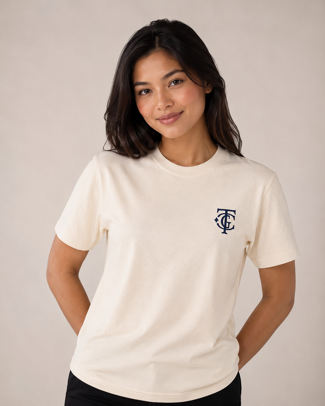 Woman wearing Cream TGC Essentials Embroidered Monogram Tee with navy TGC chest logo.