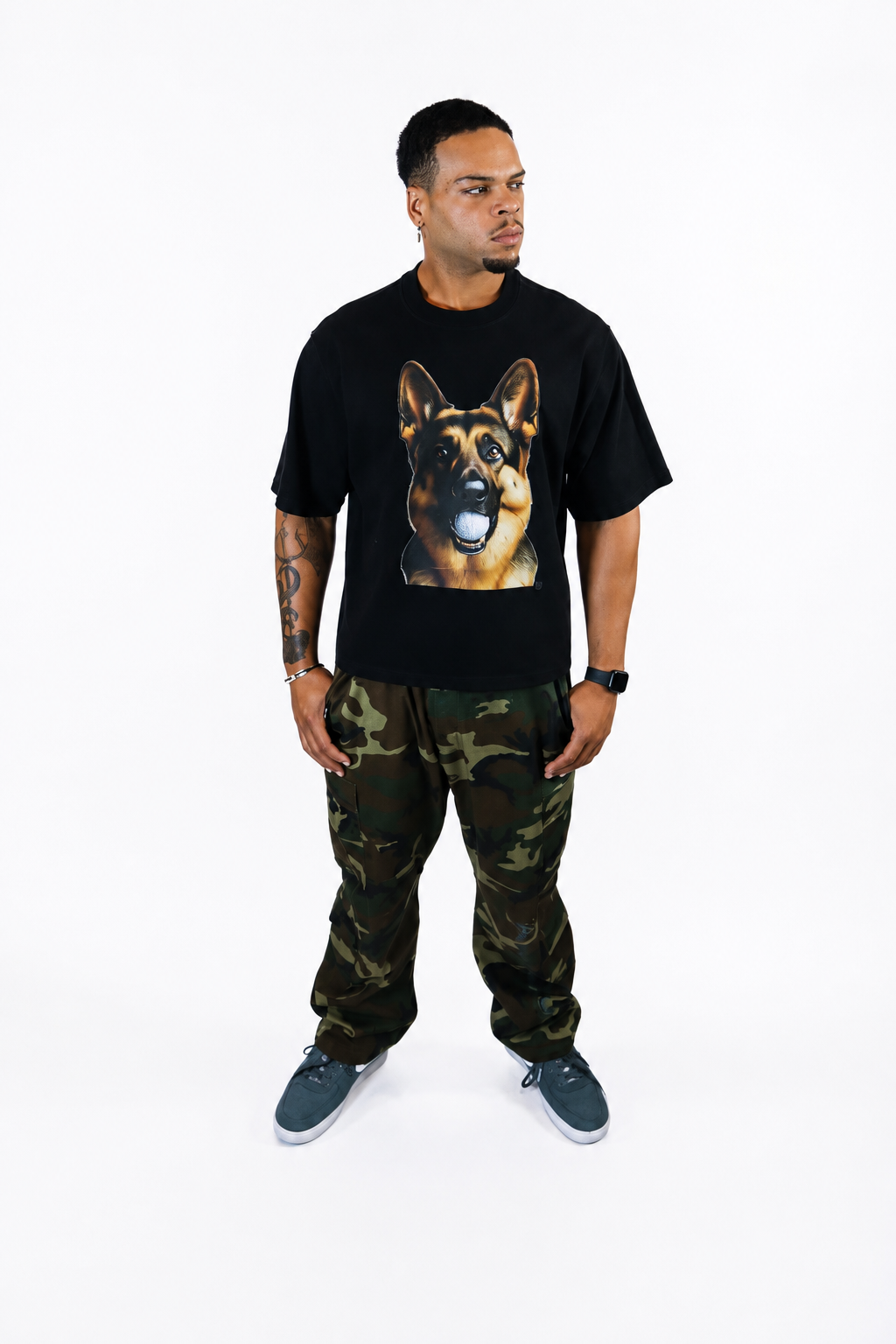 Male model wearing a black oversized Signature Hudson tee with Hudson, the German Shepherd, golf ball graphic on the front.