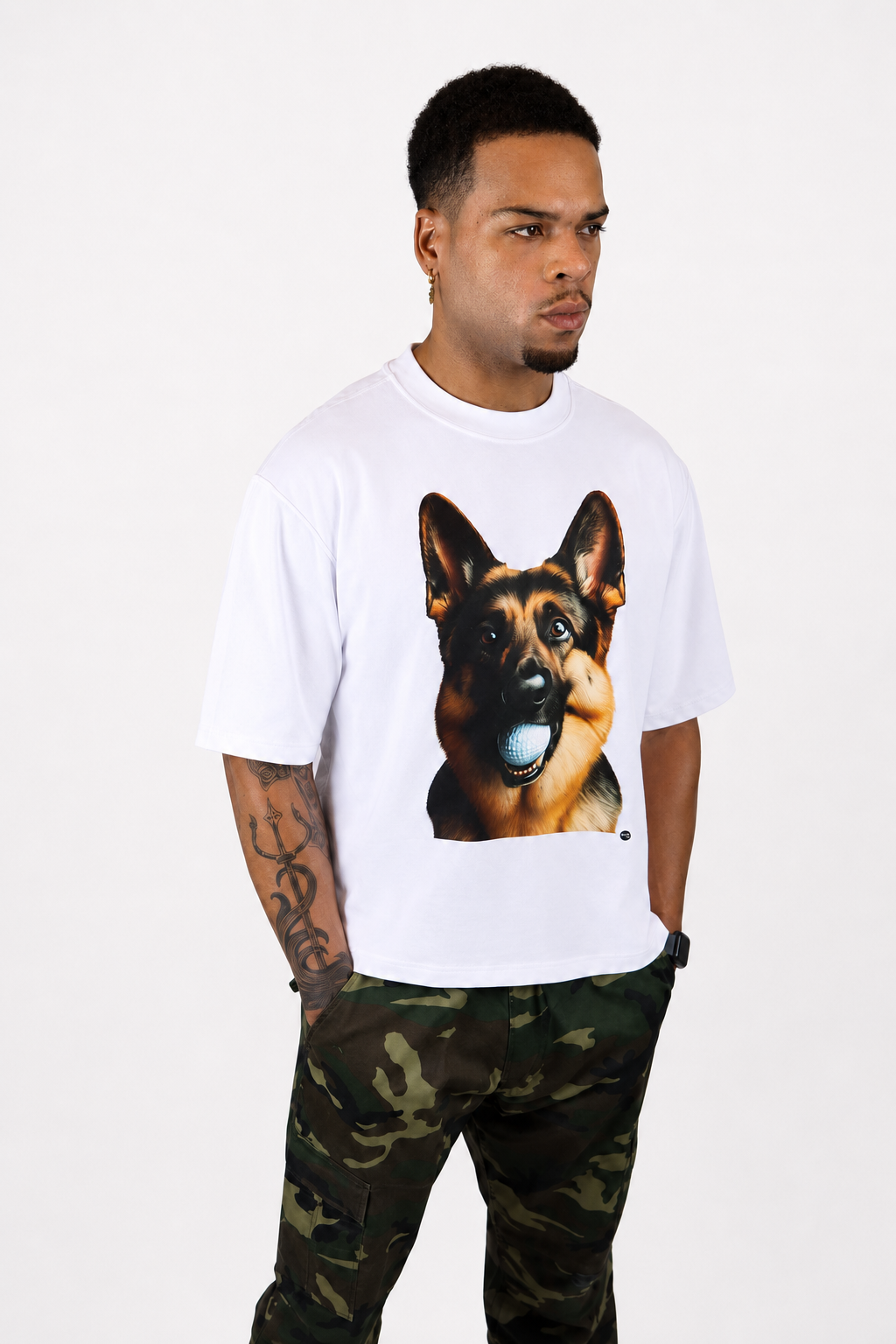 Male model wearing a white oversized Signature Hudson tee with Hudson, the German Shepherd, golf ball graphic on the front.