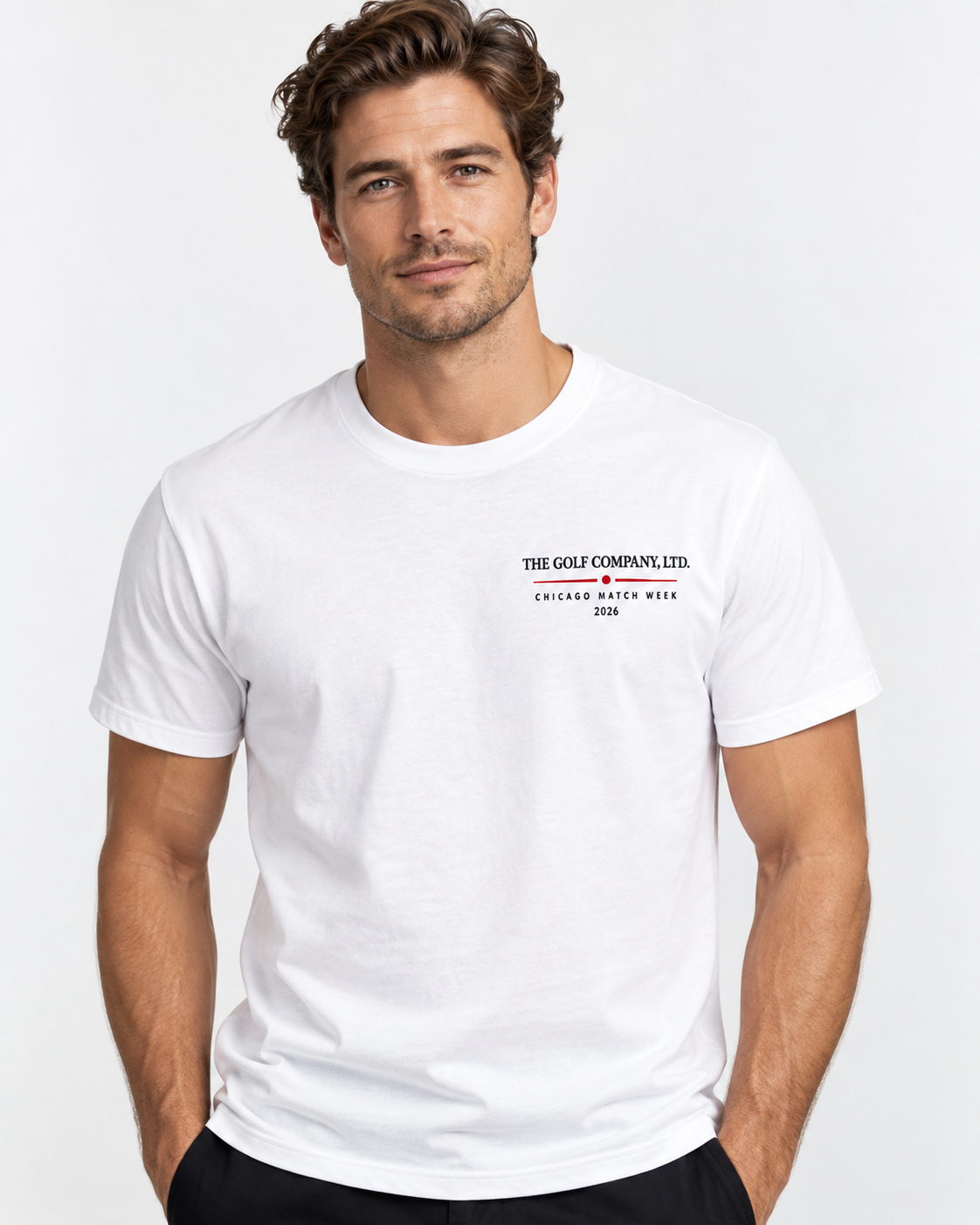 A man wearing a white short-sleeve crewneck t-shirt with a small black and red graphic on the left chest that reads 'THE GOLF COMPANY, LTD. CHICAGO MATCH WEEK 2026'.
