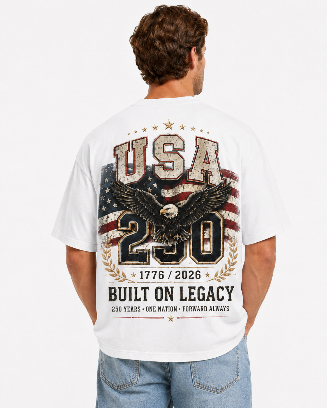 Male model wearing a white USA 250 heavyweight tee with a large distressed eagle, American flag, 1776–2026, and “Built On Legacy” back graphic.
