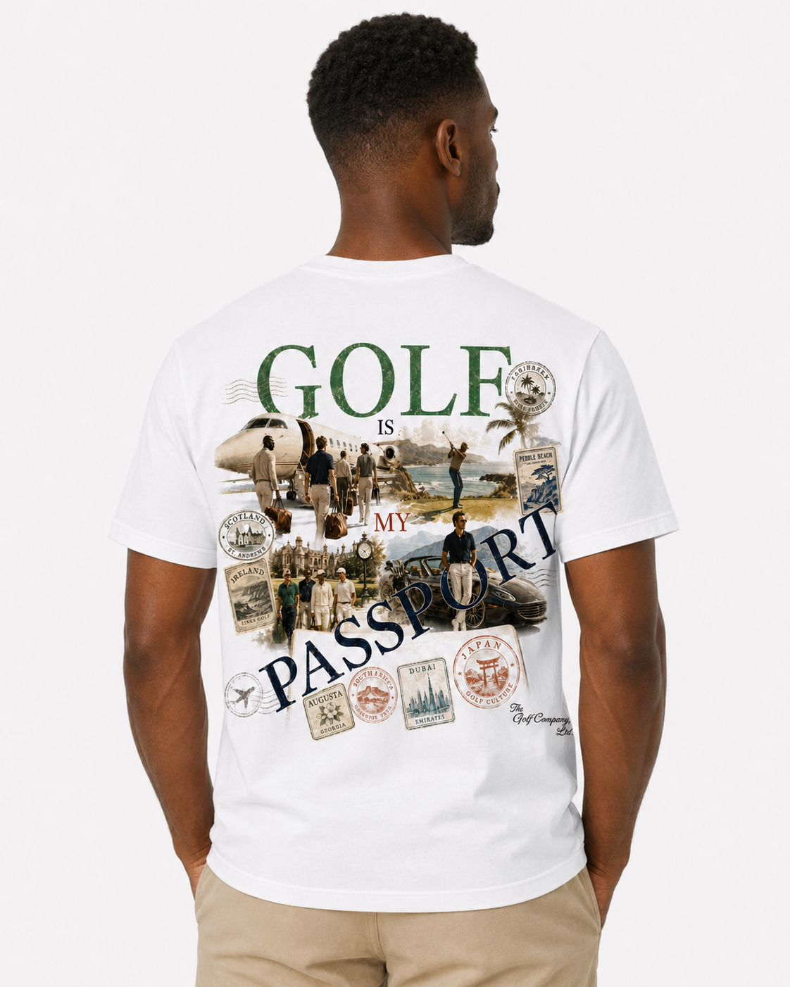 A man viewed from behind wearing a white short-sleeve t-shirt with a large graphic print on the back. The graphic features the text 'GOLF IS MY PASSPORT' in green and navy blue, alongside vintage-style travel stamps, an airplane, and golfers on a beach.
