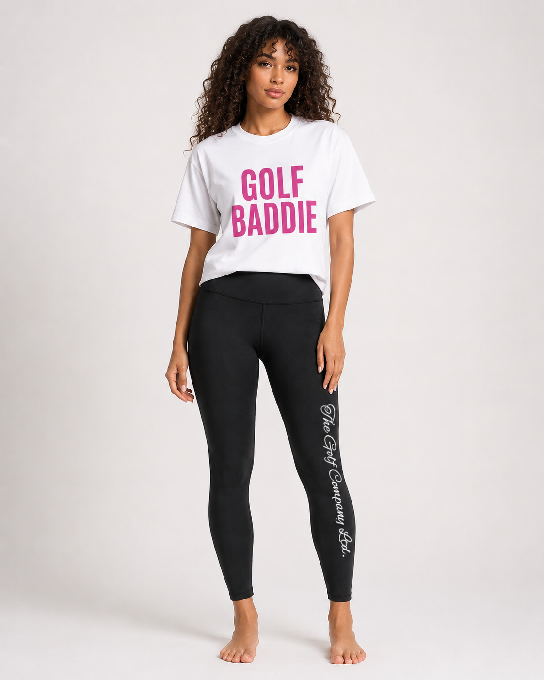 Woman wearing a white t-shirt with 'GOLF BADDIE' text and black leggings with branding on a white background