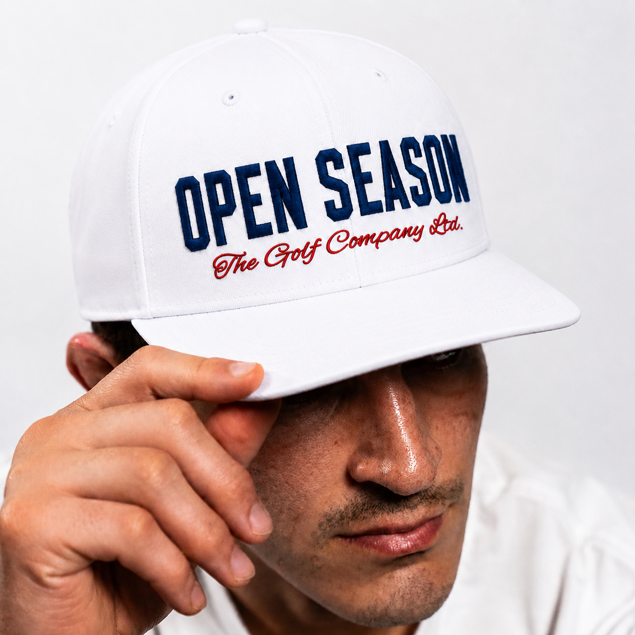 Person wearing a white cap with 'Open Season' text on a white background