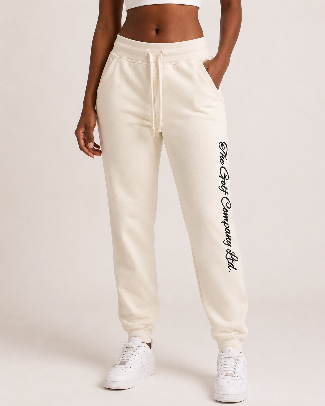 Women’s sandshell premium fleece jogger front view with The Golf Company Ltd script typography on the leg w/model