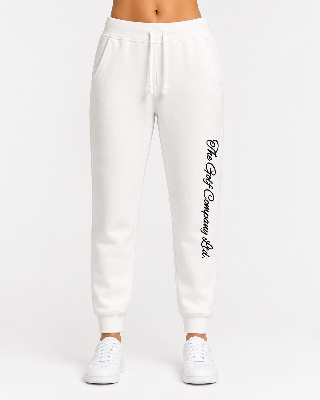 Women’s white premium fleece jogger front view with The Golf Company Ltd script typography on the leg w/model.