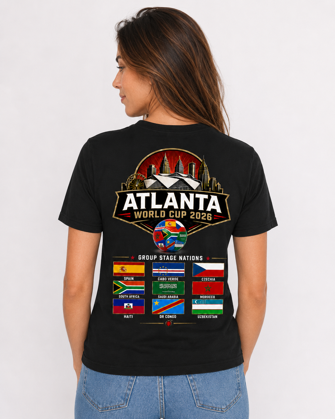 Female model wearing a black Atlanta 2026 tee with large stadium skyline back graphic and group stage nations flag artwork.