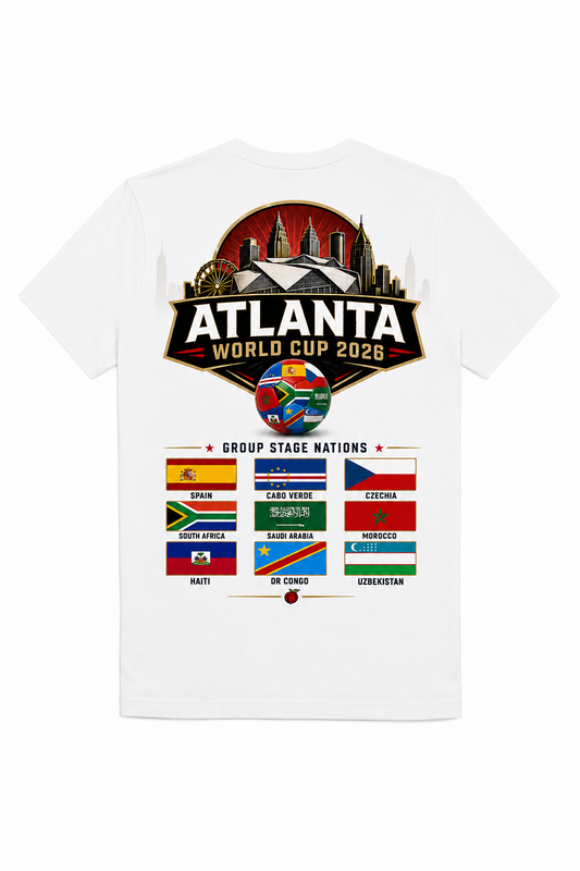 White Atlanta 2026 tee with large stadium skyline back graphic and group stage nations flags for Spain, Cabo Verde, Czechia, South Africa, Saudi Arabia, Morocco, Haiti, DR Congo, and Uzbekistan.