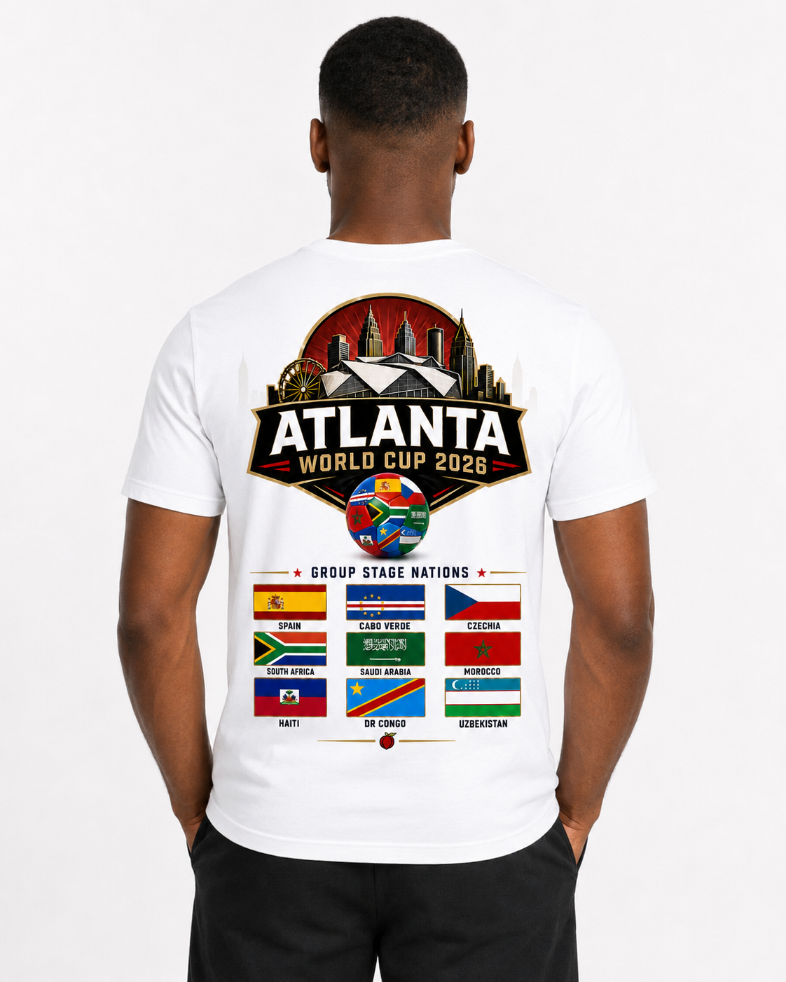 Male model wearing a white Atlanta 2026 tee with large stadium skyline back graphic and group stage nations flag artwork.